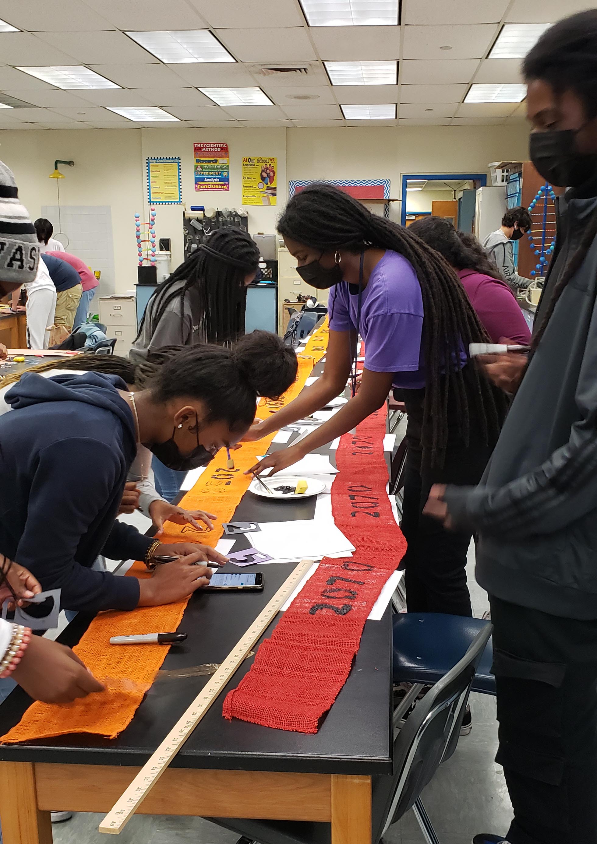 students painting dates on burlap